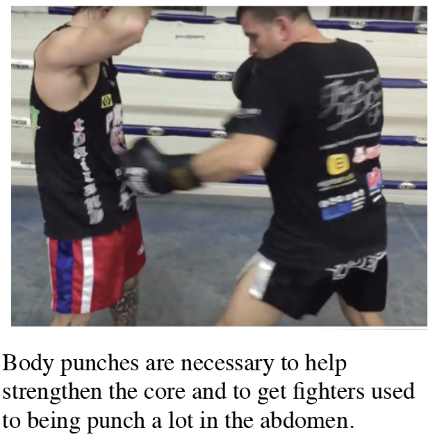 On kick boxer is punching the stomach of another kick boxer to strengthen the stomach muscles.